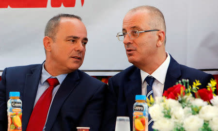 Palestinian Prime Minister Rami Hamdallah (R) sits next to Israeli Energy Minister Yuval Steinitz during the inauguration of an electrical substation near the West Bank city of Jenin July 10, 2017. REUTERS/Abed Omar Qusini