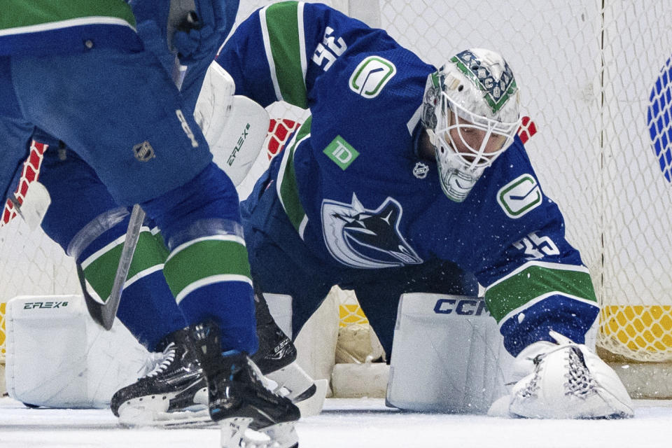 Vancouver Canucks goaltender Thatcher Demko (35) covers the puck during the first period of the team's NHL hockey game against the Winnipeg Jets on Saturday, March 9, 2024, in Vancouver, British Columbia. (Ethan Cairns/The Canadian Press via AP)