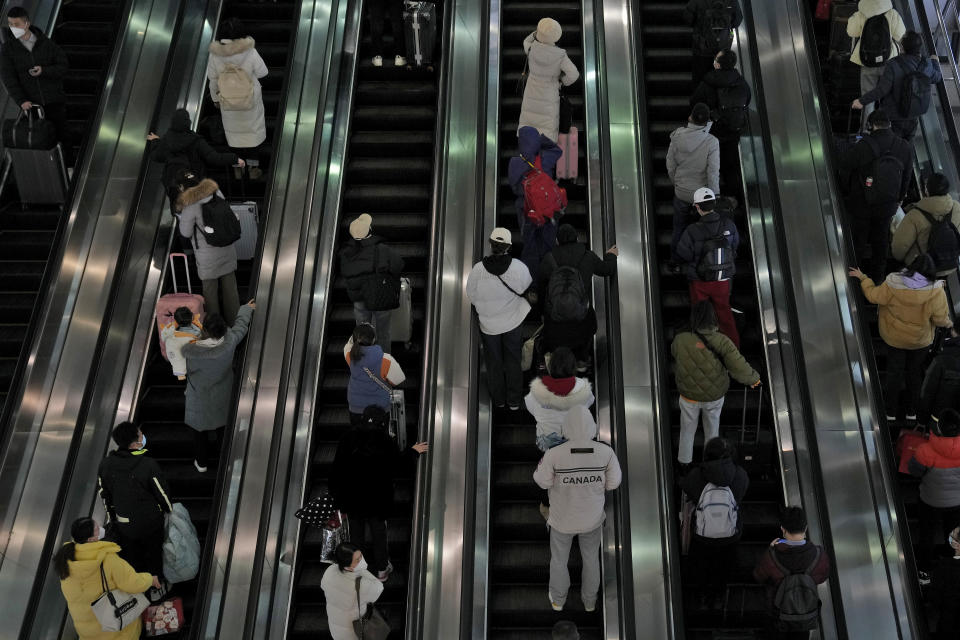 Travelers ride on the escalator as they arrive at the West Railway Station in Beijing, Sunday, Jan. 15, 2023. The World Health Organization has appealed to China to keep releasing information about its wave of COVID-19 infections after the government announced nearly 60,000 deaths since early December following weeks of complaints it was failing to tell the world what was happening. (AP Photo/Andy Wong)