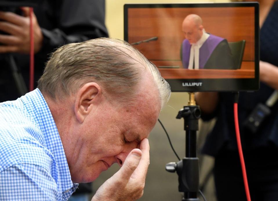 A man reacts as he listens to County Court Chief Judge Peter Kidd, on a monitor speak, during the sentencing of Cardinal George Pell who was was found guilty on historic child sex crimes.