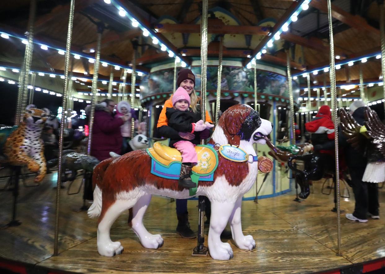 Megan Bishop and her daughter Brooklyn Clark, 2 of Wadsworth enjoy riding the carousel during the Wishes Can Happen family event at the Akron Zoo on Saturday.