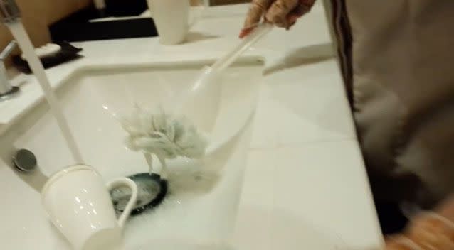The shocking video shows the cleaner washing mugs with a dirty toilet brush. Source: Pear Video