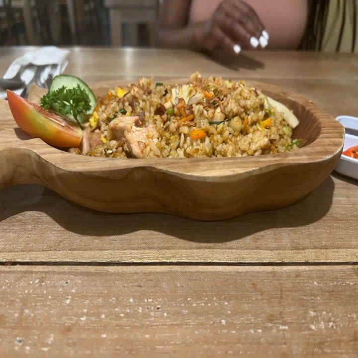 a wooden bowl of fried rice