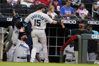 Miami Marlins' Brian Anderson (15) is greeted at the dugout by manager Don Mattingly, right, after hitting a home run during the second inning of the team's baseball game against the Atlanta Braves on Tuesday, April 13, 2021, in Atlanta. (AP Photo/John Bazemore)