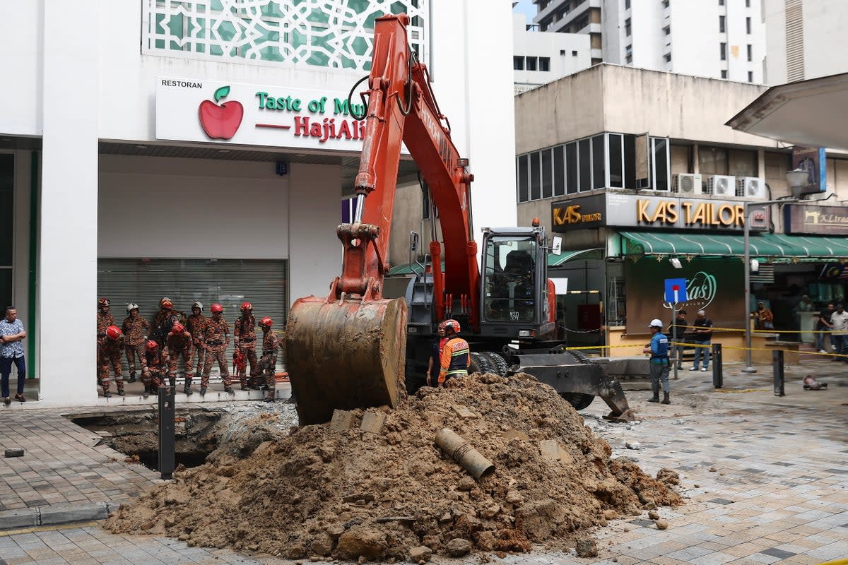 Rescue operation after woman falls into 8m-deep sinkhole in Kuala Lumpur (EPA)