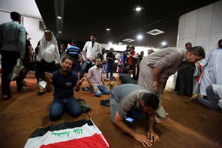 Followers of Iraq's Shi'ite cleric Moqtada al-Sadr are seen in the parliament building as they storm Baghdad's Green Zone after lawmakers failed to convene for a vote on overhauling the government, in Iraq April 30, 2016. REUTERS/Ahmed Saad