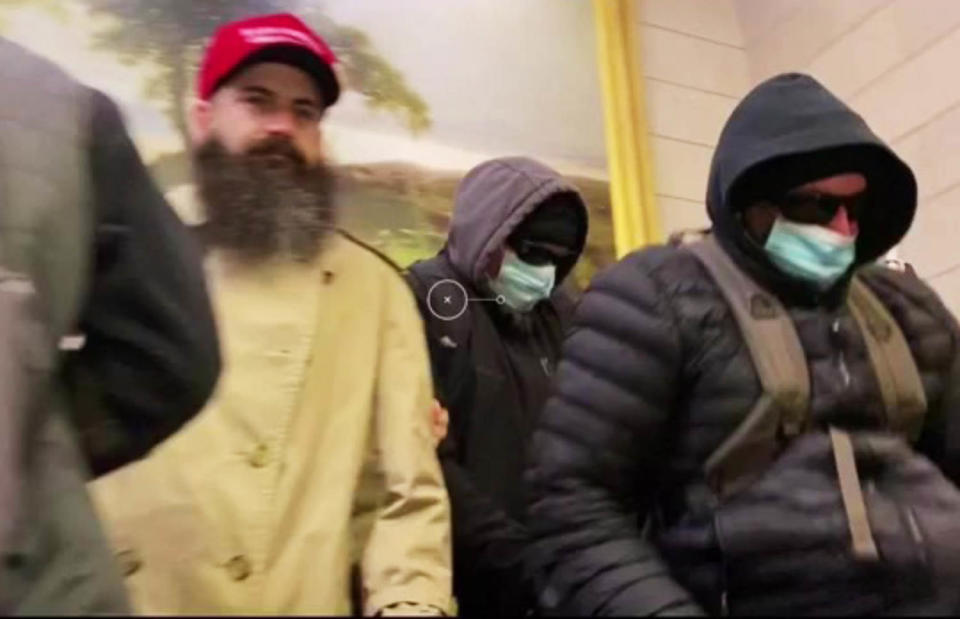 Two men identified by the FBI as the Walker brothers, pictured at right, wearing face masks after attacking a New York Times photographer.