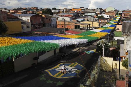 A boy rides his bicycle along Third Street of the Alvorada neighbourhood which is decorated for the 2014 World Cup in Manaus, one of the tournament's host cities, May 17, 2014. REUTERS/Bruno Kelly