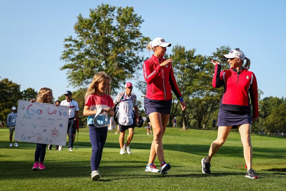 Nelly Korda and vice captain Morgan Pressel of Team USA walk to the fourth tee with two young fans (Getty Images)