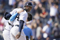 New York Yankees relief pitcher Aroldis Chapman (54) smiles as he and catcher Gary Sanchez walk out to greet teammates after escaping a jam when Oakland Athletics designated hitter Sean Murphy hit into a triple play in the ninth inning of a baseball game, Sunday, June 20, 2021, at Yankee Stadium in New York. (AP Photo/Kathy Willens)