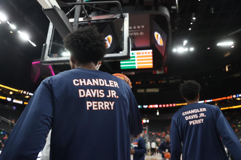 Members of the Virginia basketball team warm up Friday, Nov. 18, 2022, in Las Vegas for an NCAA college basketball game against Baylor, while wearing shirts in memory of the three students killed in a shooting nearly a week ago. (AP Photo/Chase Stevens)