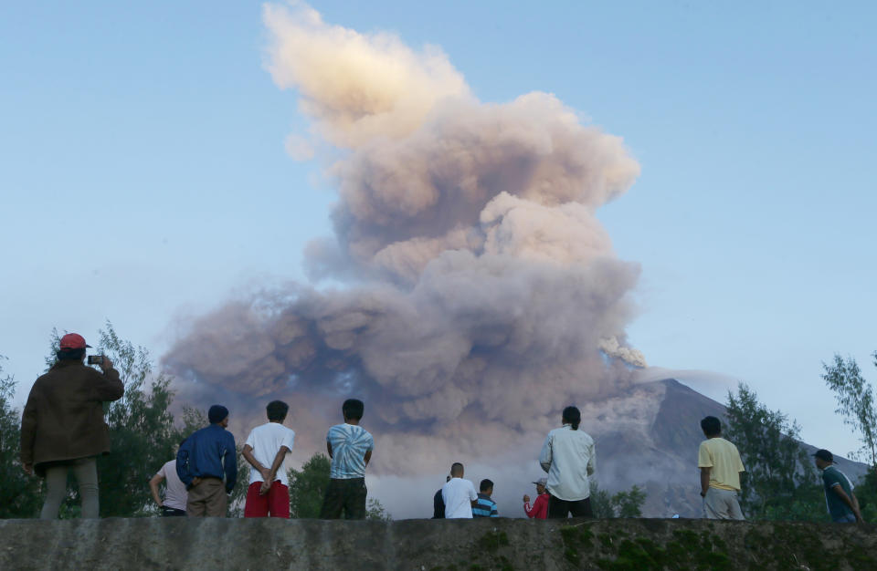 FILE- In this Jan. 24, 2018, file photo, residents watch as Mayon volcano erupts anew as seen from Legazpi city, Albay province, around 340 kilometers (200 miles) southeast of Manila, Philippines. (AP Photo/Bullit Marquez, File)