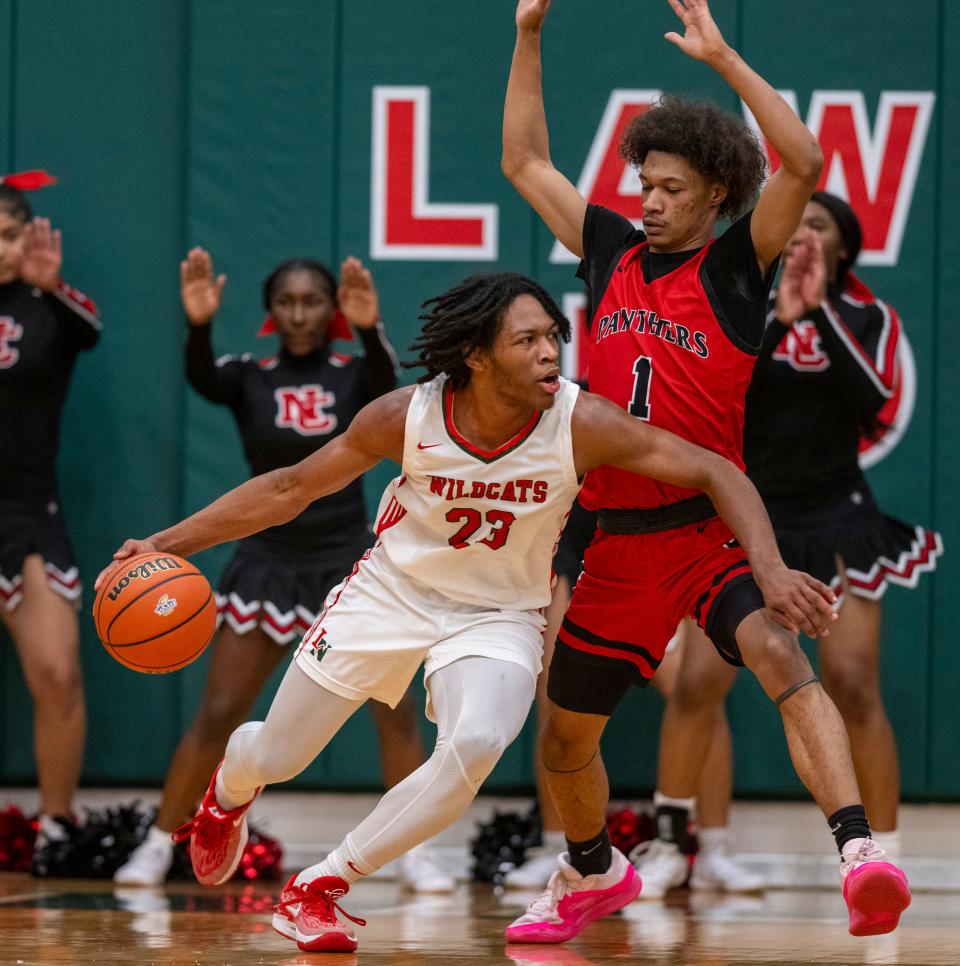 Lawrence North High School junior Azavier Robinson (23) drives to defend North Central High School senior Tim Williams, Jr. (1) during the first half of an IHSAA Class 4A boys sectional basketball game, Wednesday Thursday, February 28, 2024, at Lawrence North High School.