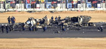 Police investigate burnt Japanese coast guard aircraft at Haneda airport on Thursday, Jan. 4, 2024, in Tokyo, Japan. A transcript of communication between traffic control and two aircraft that collided and burst into flames at Tokyo’s Haneda Airport showed that only the larger Japan Airlines passenger flight was given permission to use the runway where a coast guard plane was preparing for takeoff. (Kyodo News via AP)