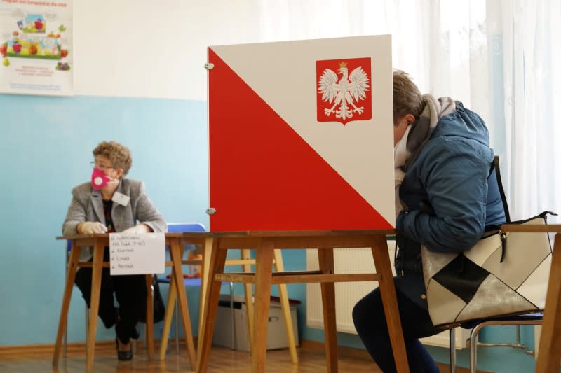 A member of a local election commission is wearing protective mask during byelections in Bemowo Pilskie