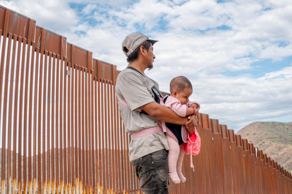 Ecuadorian migrant, Willie stands with his 4-month-old daughter Antonella while waiting to be apprehended by U.S. Customs and Border Protection officers on June 24, 2024 in Ruby, Arizona. (Photo by Brandon Bell/Getty Images)