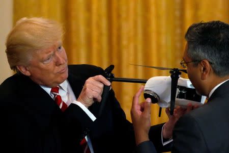 U.S. President Donald Trump (L) looks at a drone with Kespry CEO George Mathew (R) during an event highlighting emerging technologies, in the East Room at the White House in Washington, U.S., June 22, 2017. REUTERS/Jonathan Ernst