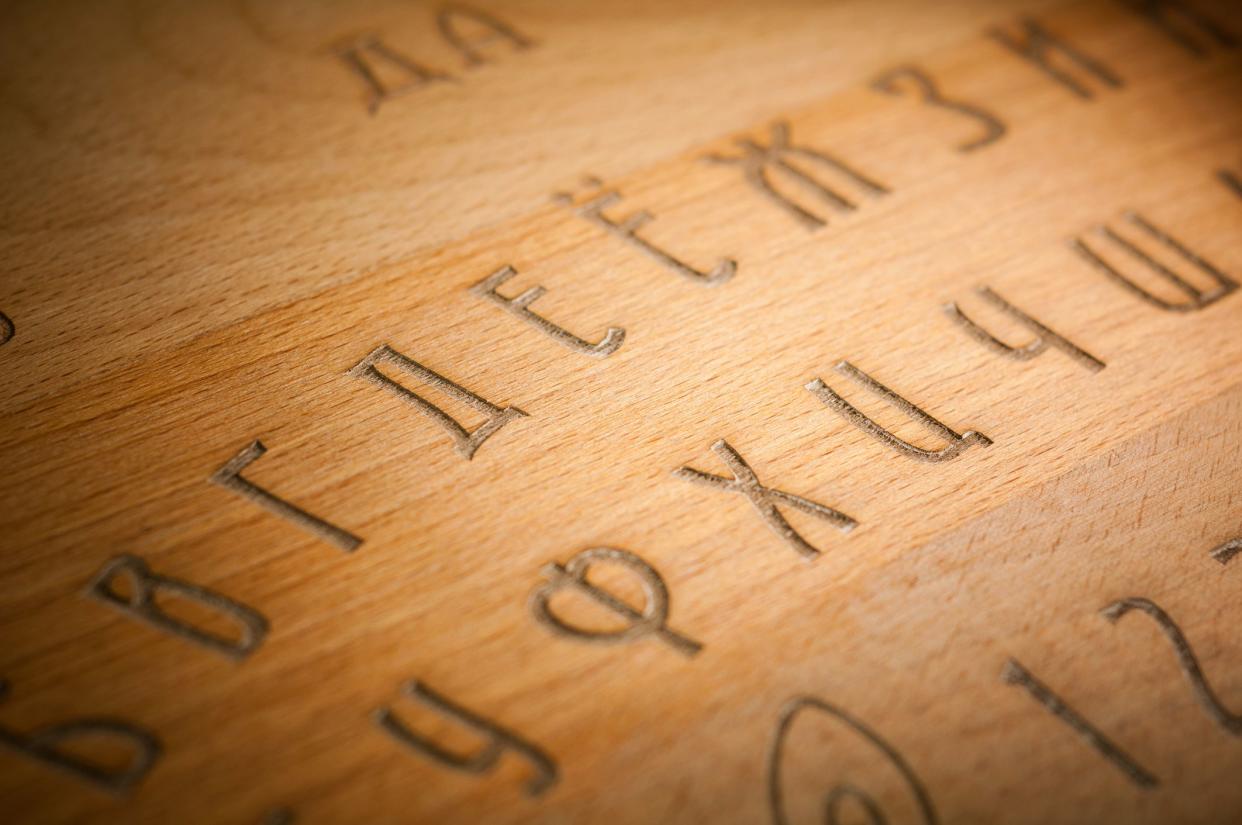 A Ouija Board, yellow on a black background