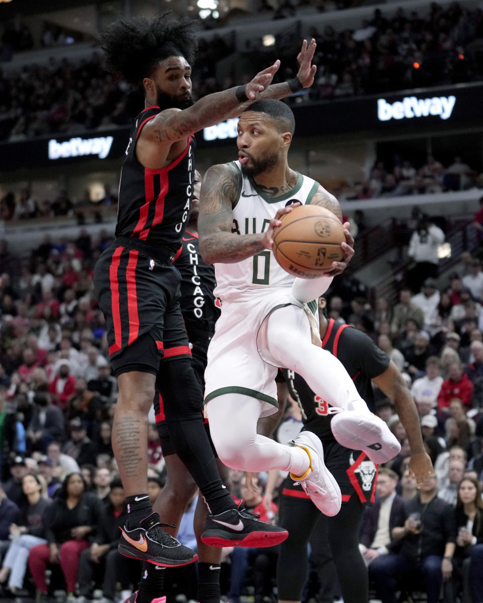 Milwaukee Bucks' Damian Lillard looks to pass the ball as Chicago Bulls' Coby White defends during the first half of an NBA basketball game Friday, March 1, 2024, in Chicago. (AP Photo/Charles Rex Arbogast)