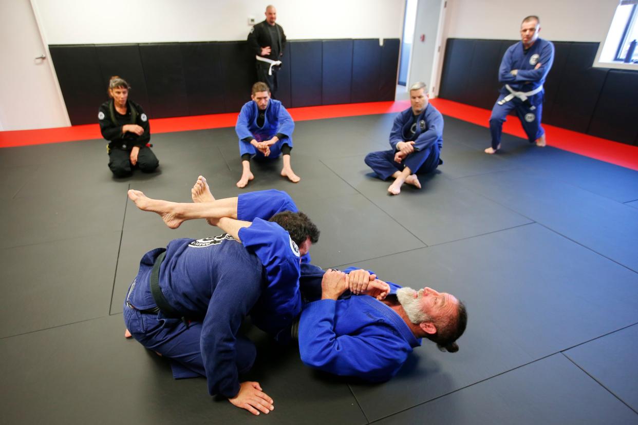 Danny Savery demonstrates a hold to students on Eric Correia at the new Danny Savery Brazilian Jiu-Jitsu on Sarah's Way in Fairhaven.