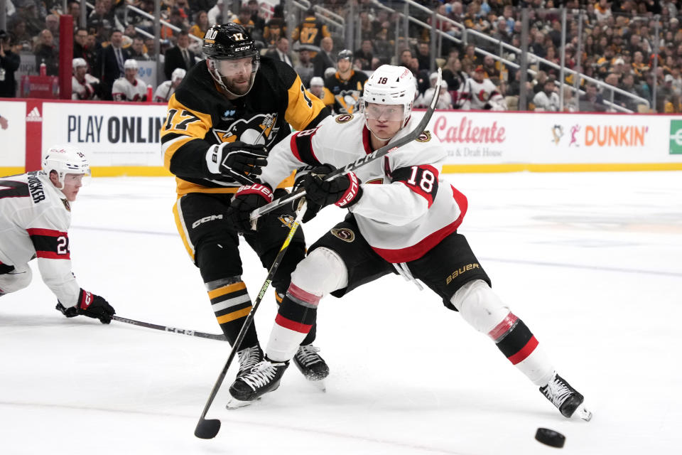 Ottawa Senators' Tim Stutzle (18) breaks up a pass intended for Pittsburgh Penguins' Bryan Rust (17) during the second period of an NHL hockey game in Pittsburgh, Saturday, Oct. 28, 2023. (AP Photo/Gene J. Puskar)