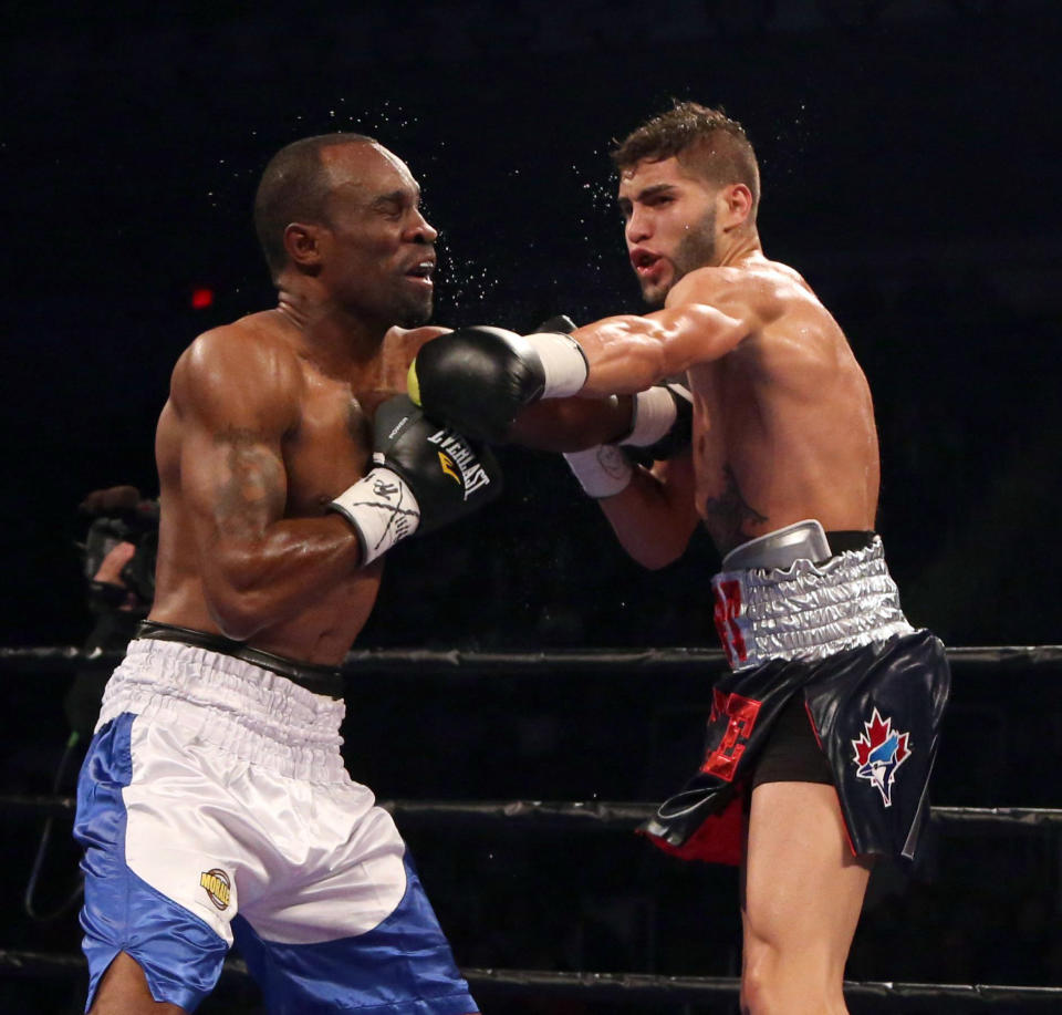 Prichard Colon, right, punches Vivian Harris during their WBC welterweight boxing match Friday, Sept. 11, 2015, in Toronto. (Peter Power/The Canadian Press via AP) MANDATORY CREDIT