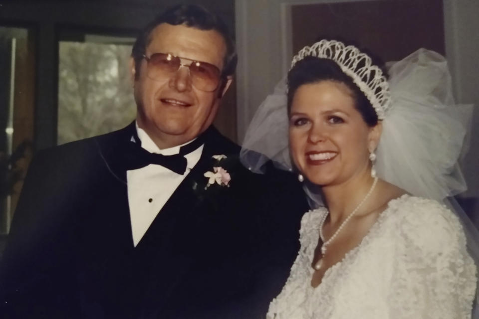 This 1997 photo provided by Kelly Forrester shows her with her father, Virgil Michlitsch, during her wedding at Inver Grove Heights, Minn. “I wish we could go back to before COVID,” said Forrester, 52, of Shakopee, Minn., who lost her father to the disease in May 2020, survived her own bout in December and blames misinformation for ruining a longtime friendship. “I hate it. I actually hate it.” (Courtesy Kelly Forrester via AP)