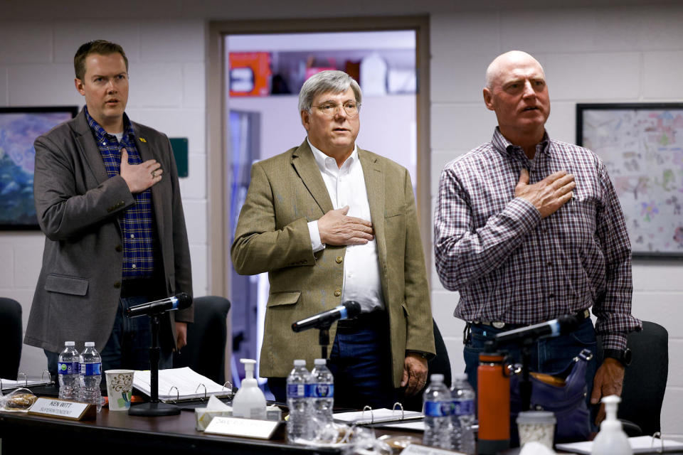 Woodland Park School Board Vice President David Illingworth II, left, Interim Superintendent Kenneth Witt, center, and President David Rusterholtz, right, say the Pledge of Allegiance before the start of the Board of Education meeting on April 12, 2023 in Woodland Park, Colo. (Michael Ciaglo for NBC News)