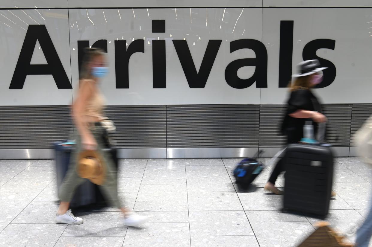 Passengers wearing face masks as a precautionary measure against COVID-19, walk through the arrivals hall after landing at London Heathrow Airport in west London, on January 15, 2021. - International travellers will need to present proof of a negative coronavirus test result in order to be allowed into England, or face a £500 ($685, 564 euros) fine on arrival, from January 18. (Photo by DANIEL LEAL-OLIVAS / AFP) (Photo by DANIEL LEAL-OLIVAS/AFP via Getty Images)