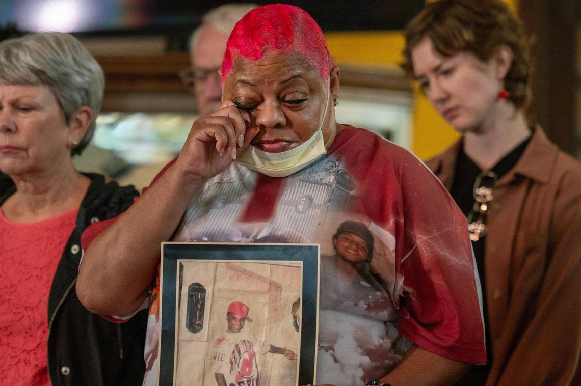 Vicki Ford wipes away tears while holding a photo of her son, Delvin Matthews, who was murdered 25 years ago, during a press conference at Grandview Park Presbyterian Church on Tuesday, Nov. 14, 2023, in Kansas City, Kan. Metro Organization for Racial and Economic Equity held a press conference to call on the U.S. Department of Justice to investigate persistent misconduct in the Kansas City, Kansas Police Department, highlighting the urgent need for federal intervention and community healing.