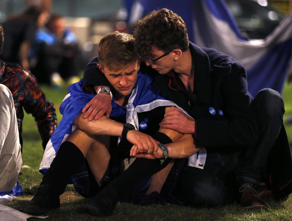 Supporters from the "Yes" Campaign react as they sit in George Square in Glasgow, Scotland