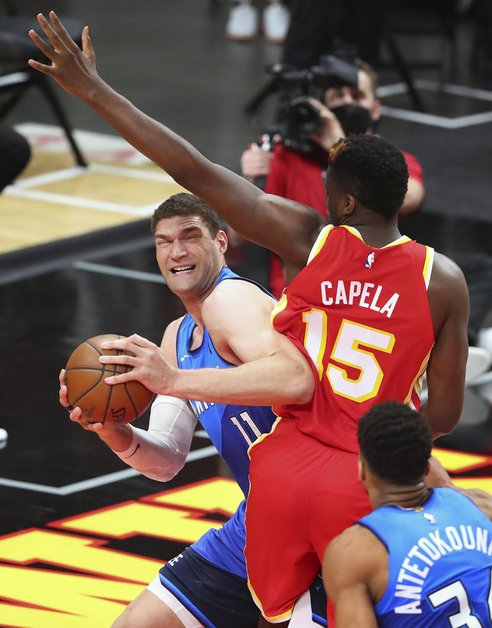 Atlanta Hawks center Clint Capela fouls Milwaukee Bucks center Brook Lopez, left, during the second quarter in Game 3 of the NBA Eastern Conference basketball finals, Sunday, June 27, 2021, in Atlanta. (Curtis Compton/Atlanta Journal-Constitution via AP)