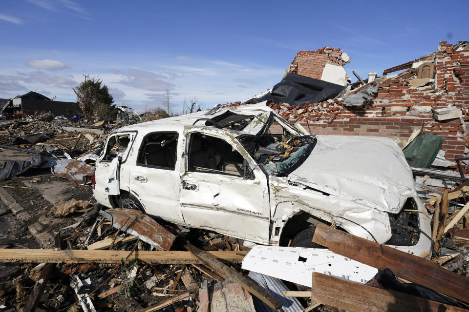 People survey damage from a tornado is seen in Mayfield, Ky., on Saturday, Dec. 11, 2021. Tornadoes and severe weather caused catastrophic damage across multiple states late Friday, killing several people overnight. (AP Photo/Mark Humphrey)