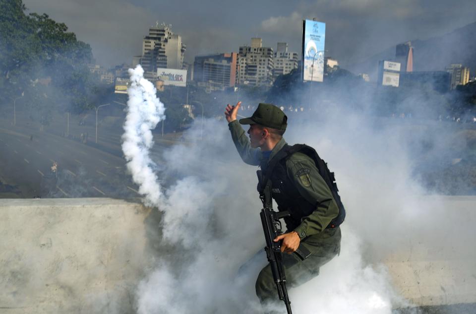 A member of the Bolivarian National Guard supporting Venezuelan opposition leader and self-proclaimed acting president Juan Guaido throws a tear gas canister during a confrontation with guards loyal to President Nicolas Maduro's government in front of La Carlota military base in Caracason April 30, 2019. Yuri Cortez/AFP/Getty Images)