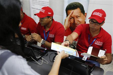 A passenger presents her documents at a special check point of the state currency board Cadivi in the Simon Bolivar airport in La Guaira, outside Caracas October 15, 2013. REUTERS/Carlos Garcia Rawlins