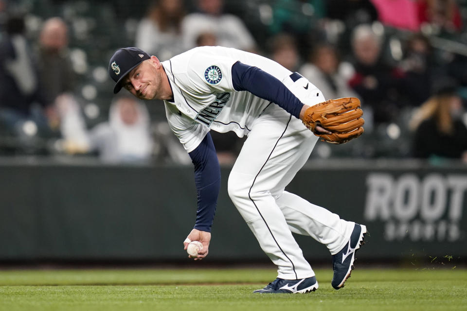 Seattle Mariners third baseman Kyle Seager barehands a grounder from Texas Rangers' Isiah Kiner-Falefa during the fourth inning of a baseball game, Thursday, May 27, 2021, in Seattle. Kiner-Falefa singled on the play. (AP Photo/Elaine Thompson)