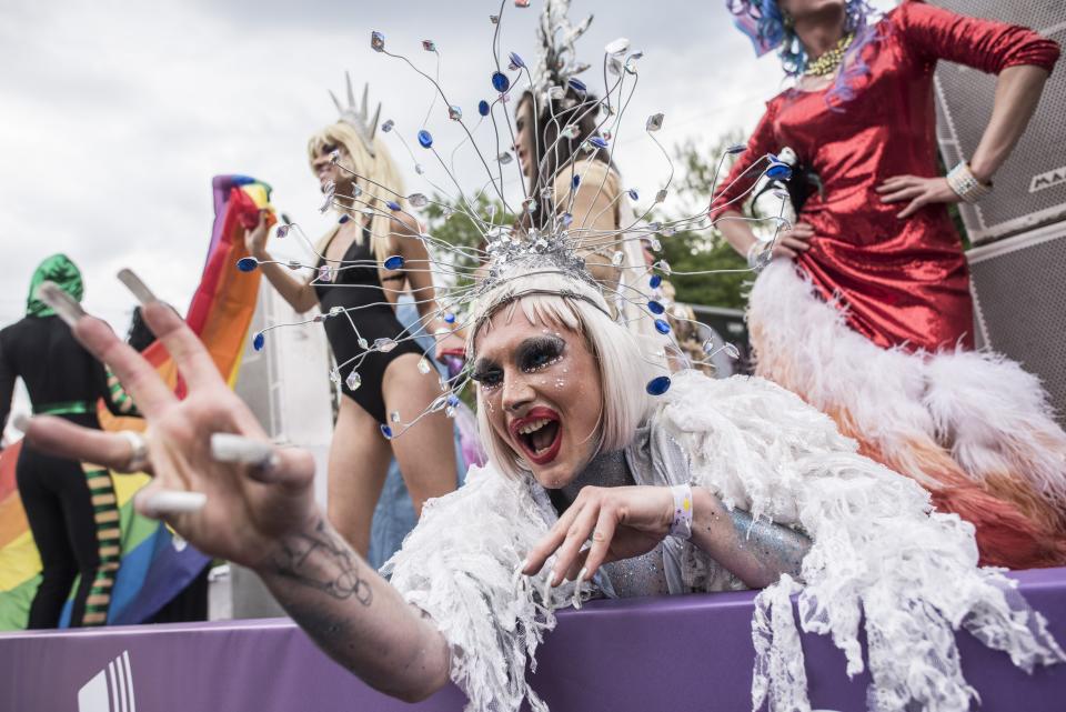 FILE - Gay and lesbian rights activists perform during the annual Gay Pride parade, protected by riot police in Kyiv, Ukraine, Sunday, June 17, 2018. Despite the war in Ukraine, the country's largest LGBT rights event, KyivPride, is going ahead on Saturday, June 25, 2022. But not on its native streets and not as a celebration of gay pride. It will instead join Warsaw's yearly Equality Parade, using it as a platform to keep international attention focused on the Ukrainian struggle for freedom. (AP Photo/Evgeniy Maloletka, File)