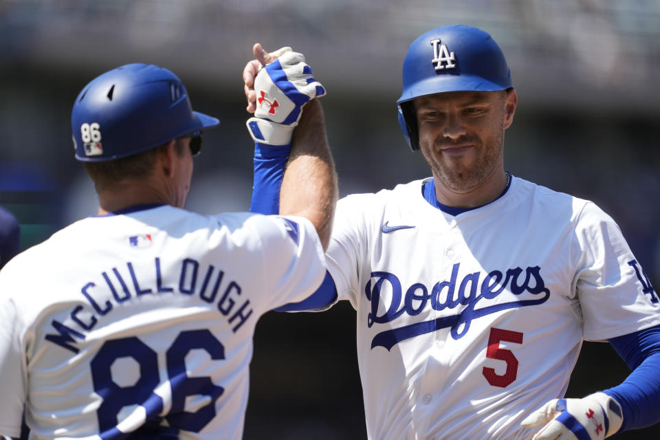 Los Angeles Dodgers' Freddie Freeman (5) celebrates with first base coach Clayton McCullough (86) after a single during the fourth inning of a baseball game against the Tampa Bay Rays in Los Angeles, Sunday, Aug. 25, 2024. (AP Photo/Ashley Landis)