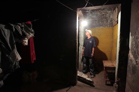 A resident living in a building damaged by a previous earthquake in 1972 is seen after a magnitude 6.1 earthquake shook western Nicaragua April 10, 2014. REUTERS/Oswaldo Rivas