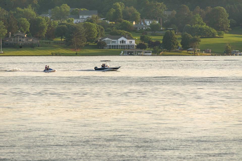 A boat driving past homes on Lake Anna