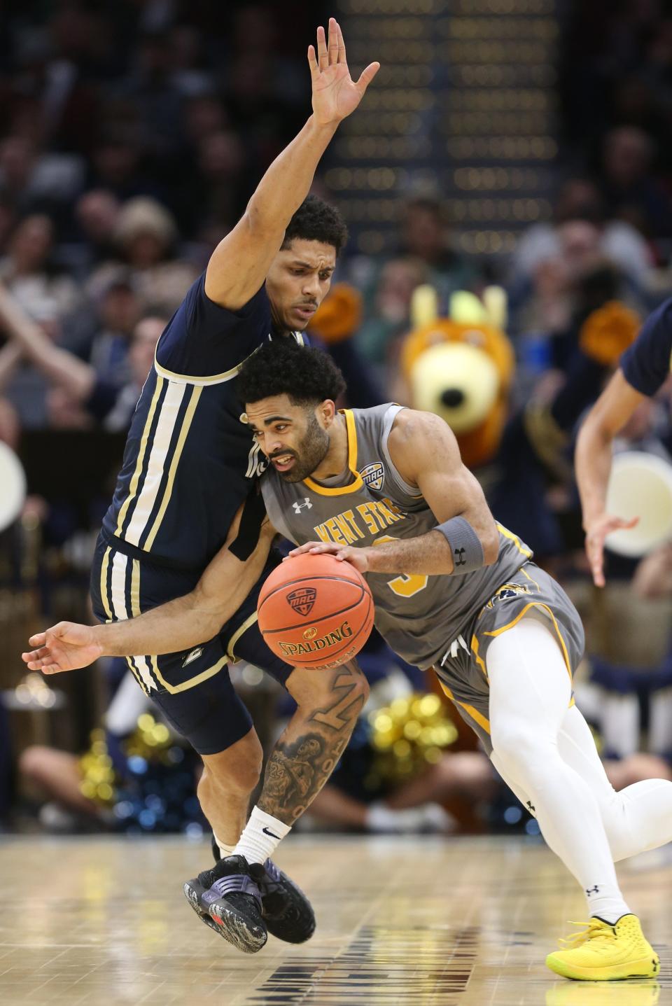 Kent State guard Sincere Carry, right, drives against University of Akron guard Xavier Castaneda in the first half of the Mid-American Conference Tournament final Saturday night at Rocket Mortgage FieldHouse in Cleveland. [Phil Masturzo/Beacon Journal]