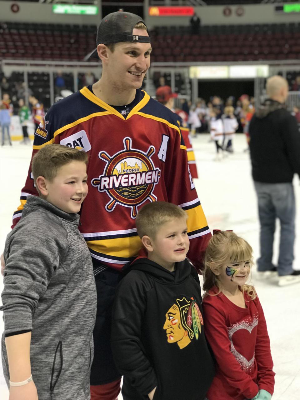 Peoria Rivermen assistant captain Ben Oskroba stops for photos with fans during a post-game skate at Carver Arena.