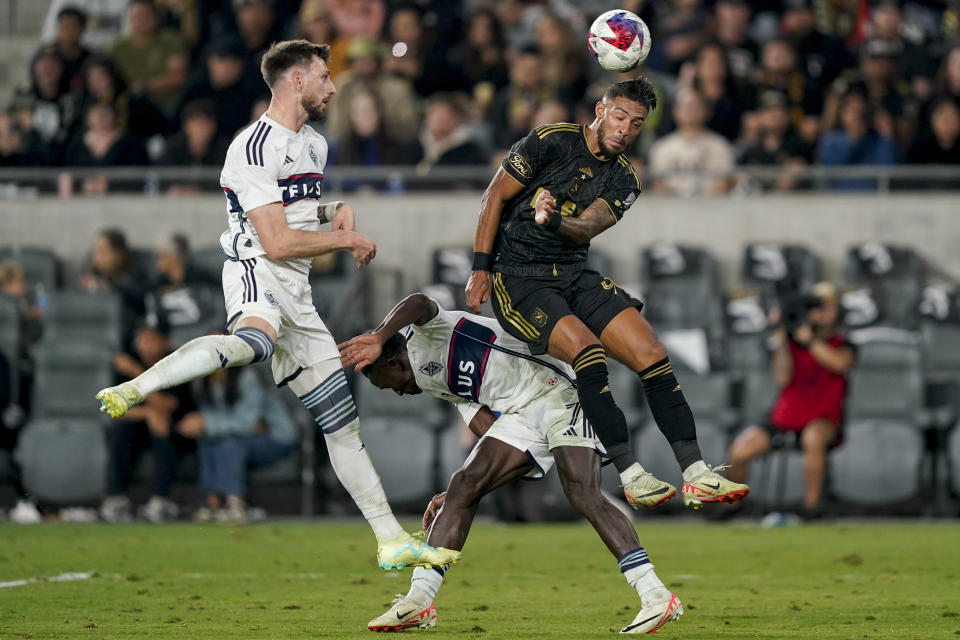 Los Angeles FC forward Denis Bouanga, top right, and Vancouver Whitecaps midfielder Richie Laryea, bottom, and defender Tristan Blackmon vie for the ball during the second half of an MLS playoff soccer match Saturday, Oct. 28, 2023, in Los Angeles. (AP Photo/Ryan Sun)