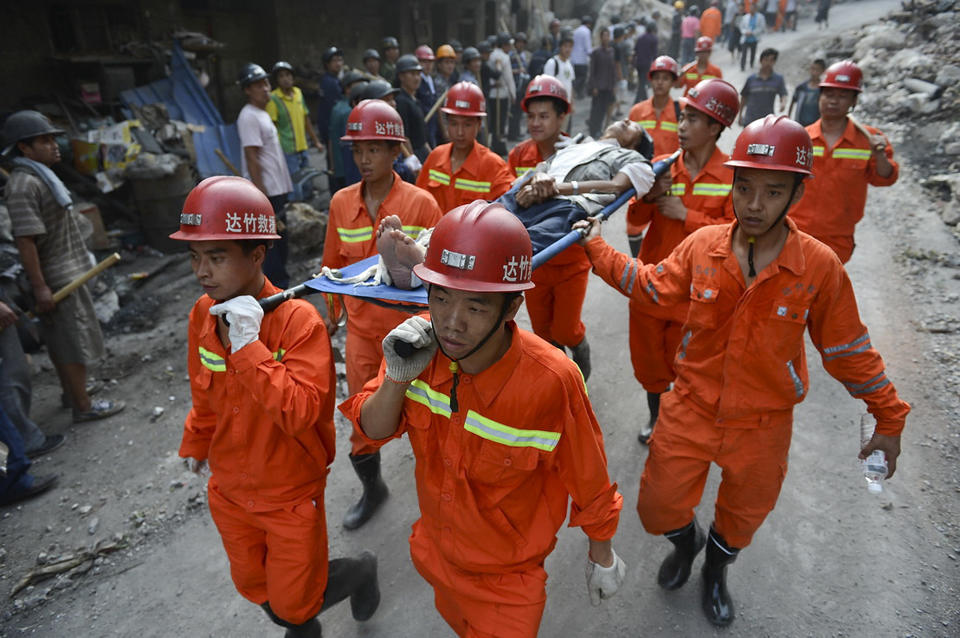 Rescuers carry an injured victim evacuated from an earthquake hit Luozehe town in Yiliang county in southwest China's Yunnan province Saturday, Sept. 8, 2012. Authorities poured aid into a remote mountainous area of southwestern China and rescue workers with sniffer dogs searched for survivors Saturday after twin earthquakes killed at least 80 people. (AP Photo) CHINA OUT