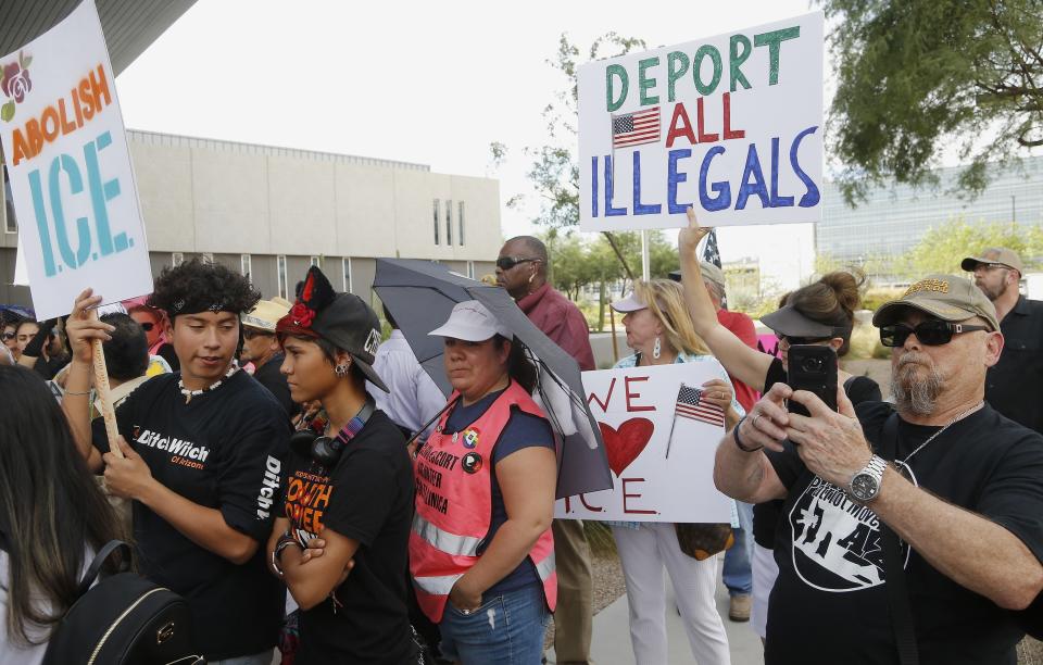 Immigration activists, left, protest against the Maricopa County Sheriff and Immigration and Customs Enforcement at the county jail in an ongoing effort to get immigration authorities out as counter demonstrators gather as well Wednesday, Aug. 22, 2018, in Phoenix. (AP Photo/Ross D. Franklin)