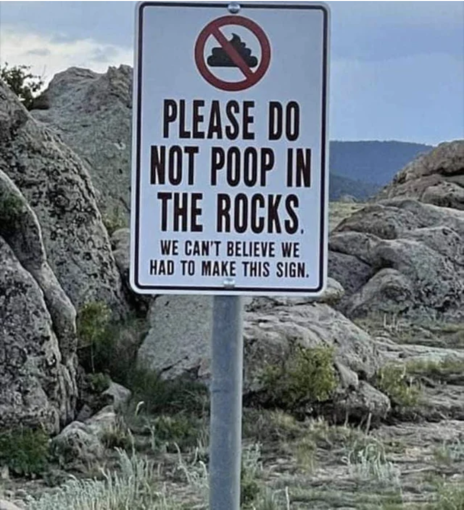 The sign says "please do not poop in the rocks, we can't believe we had to make this sign"