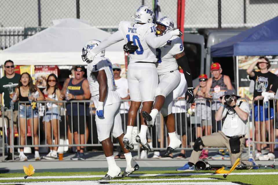 Middle Tennessee defensive end Jordan Ferguson (9) and defensive tackle Ja'Kerrius Wyatt (10) leap after a Ferguson touchdown against San Diego State during the first half of the Hawaii Bowl NCAA college football game, Saturday, Dec. 24, 2022, in Honolulu. (AP Photo/Marco Garcia)