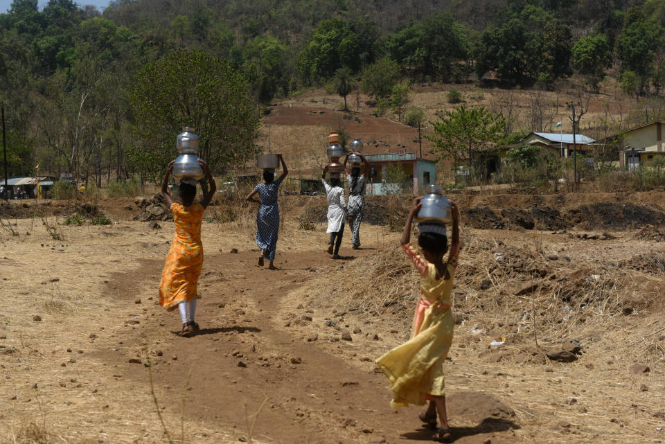 Dorfbewohner tragen während einer anhaltenden Hitzewelle in Kasara, Indien, am 1. Mai 2024 mit Wasser gefüllte Töpfe aus einem Brunnen. / Bildnachweis: Indranil Aditya/NurPhoto/Getty