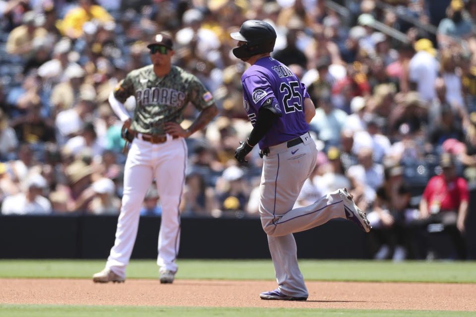 Colorado Rockies' C.J. Cron runs the bases after hitting a solo home run as San Diego Padres third baseman Manny Machado looks on in the fourth inning of a baseball game Sunday, July 11, 2021, in San Diego. (AP Photo/Derrick Tuskan)