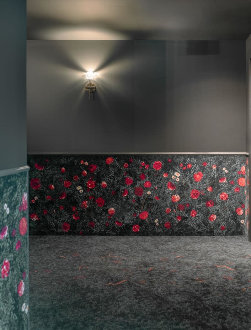 Gray carpet with red and pink roses, carpet up half wall to railing trim